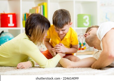 kid boy, his father and mother competing in physical strength