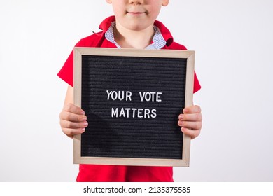 Kid Boy Holding Letter Board With Text Your Vote Matters On White Background