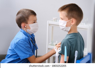 Kid, A Boy Holds A Medical Stethoscope In His Hand And Listens To Another Child, A Protective Mask On His Face, A Concept Of Health, Disease Treatment, Coronavirus, COVID-19, Life Insurance