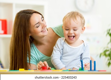 kid boy and mother playing at table at home