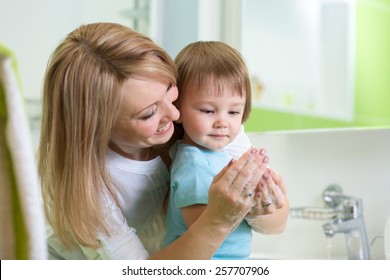 Kid Boy And Mother Washing Hands With Soap In Bathroom