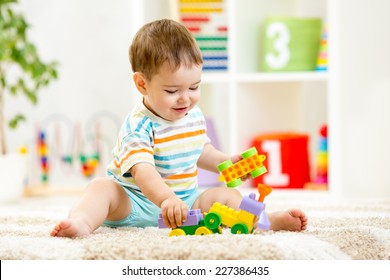 kid boy playing with building blocks at home or kindergarten