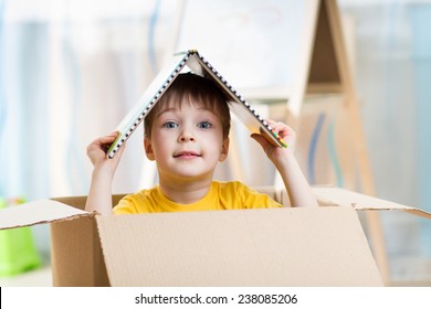 Kid Boy Playing In A Toy House In Children Room