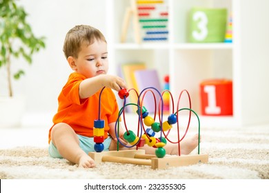 kid boy plays with educational toy indoors