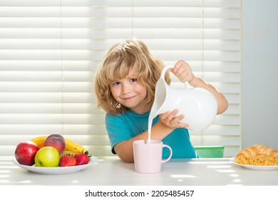 Kid Boy Pouring Whole Cows Milk. Portrait Of Child Eat Fresh Healthy Food In Kitchen At Home. Kid Boy Eating Breakfast Before School.