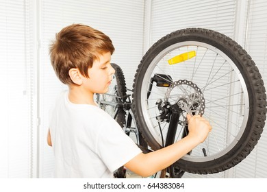 Kid Boy Repairing His Bicycle At Garage