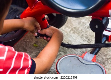 Kid Boy Repairing His Red Bicycle At Park