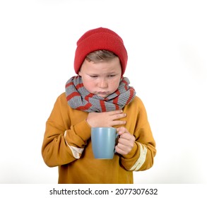 Kid Boy Is Sick With Cup Of Tea Isolated On White Background. Child In Scarf And Hat Coughs. San Unhappy School Kid Face. Allergic Kid, Flu Season. Kid With Cold Rhinitis, Get Cold.