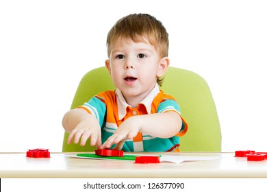 Kid Boy Sitting At Table And Playing With Colorful Clay Toy