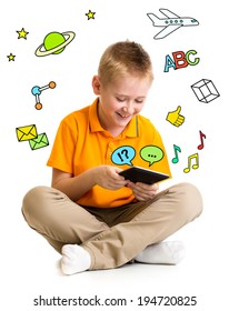 Kid boy sitting with tablet computer and learning or playing with great interest