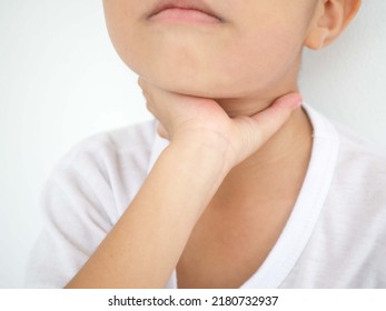 Kid Boy With Sore Throat Touching Her Neck, Feeling Pain In His Throat Caused By Tonsillitis. Closeup Photo, Blurred.