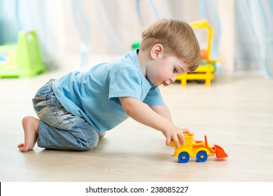 Kid Boy Toddler Playing With Toy Car Indoors