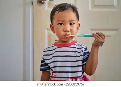 Kid Brushing Teeth. Kids Toothbrush And Paste. Asian Kid Brushing His Teeth In White Bathroom. Dental And Heath For Children.