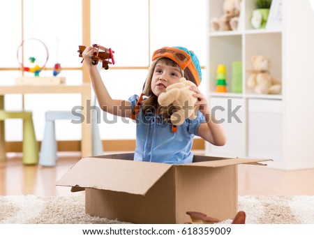 Kid child pilot flying a cardboard box in kid room