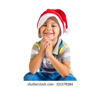 Kid With Christmas Hat Sitting On Big Yellow Gift