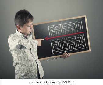 Kid Is Considering How To Shorten The Path Through The Maze ,  Drawing On A Blackboard