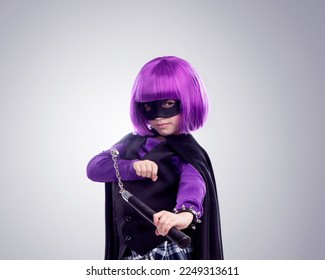 Kid, costume girl or vigilante in studio portrait with nunchaku, fantasy or creative comic clothes. Kid, superhero aesthetic, mask and creative for martial arts, villain or cosplay by gray background - Powered by Shutterstock