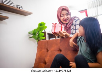 Kid Daughter Giving A Suprise Gift Box To Her Mum
