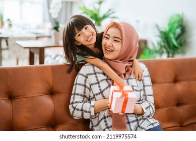 Kid Daughter Giving A Suprise Gift Box To Her Mum