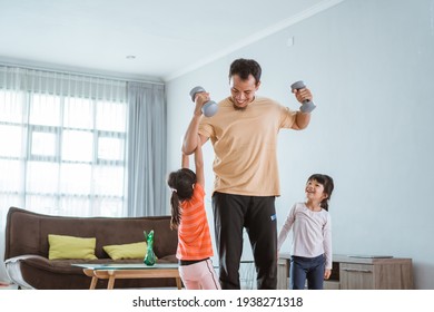 kid disturb his daddy while doing sport at home
