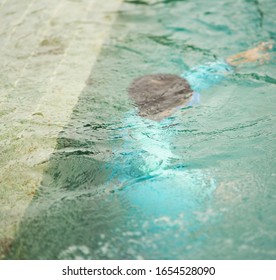 Kid diving under water like drowning in safty swimming pool concept