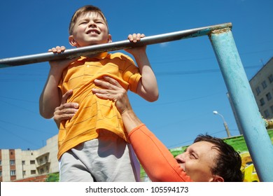 Kid Doing Chin-ups, His Father Helping Him