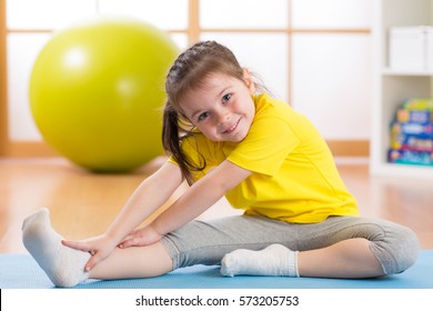 Kid Doing Fitness Exercises At Home In Her Room