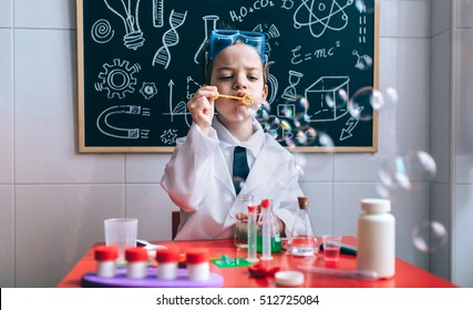 Kid doing soap bubbles against of drawn blackboard