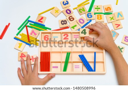 kid doing subtraction equation using counting rods