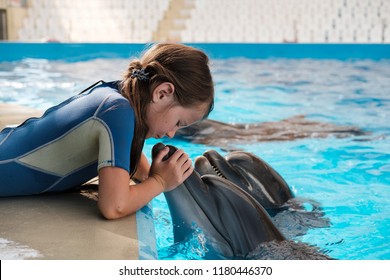 Kid and Dolphin. girl hugging and kissing bottlenose dolphin. Dolphin Assisted Therapy - Shutterstock ID 1180446370