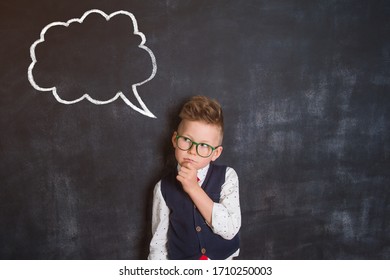 Kid with drawn cloud on blackboard. Funny thinking child boy