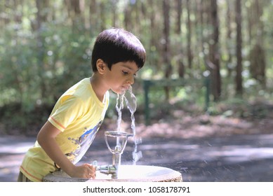 
Kid drinking water. Outdoor shot of child drinking water from tap or water bubbler or fountain.					 - Powered by Shutterstock