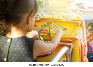 Kid Driving Toy Car Ride At An Amusement Park.