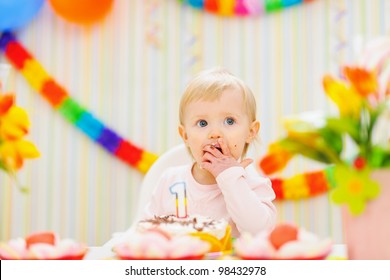 Kid eating first birthday cake
