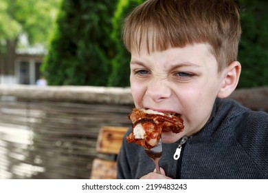 Kid Eating Grilled Chicken Wings On Restaurant Terrace