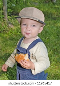 Kid Eating The Roll In The Park Outdoor