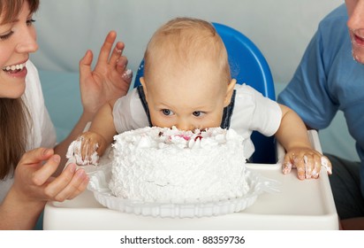 Kid eats cake. Family celebrates the first birthday of his son.