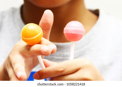 Kid enjoy eat lollipops / A lollipop is a type of sugar candy usually consisting of hard candy mounted on a stick - Shutterstock ID 1058221418