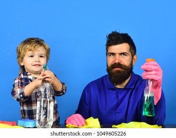 Kid with father holds cleaning sprays on blue background.  - Shutterstock ID 1049605226