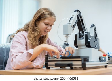 Kid female teen child enjoy Machine Learning Robot arm is Moving Under Control robot at technology class, stem education robot arms for digital automation software for artificial intelligence ai - Shutterstock ID 2364466591