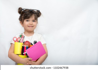 Kid Gets Ready For School. Schoolgirl Holding Many School Supplies: Pens, Notebooks, Scissors And Apple. Back To School Concept. Space For Text, Isolated On White.