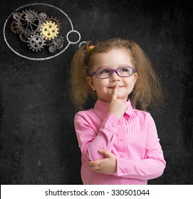 Kid Girl In Glasses With Bright Idea Standing Near School Blackboard 