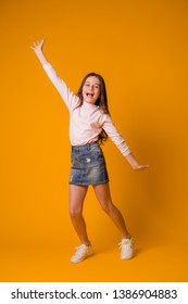 kid girl jumping happy girl dancing on yellow background - Shutterstock ID 1386904883