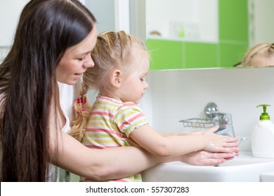 Kid Girl And Mother Washing Hands With Soap In Bathroom