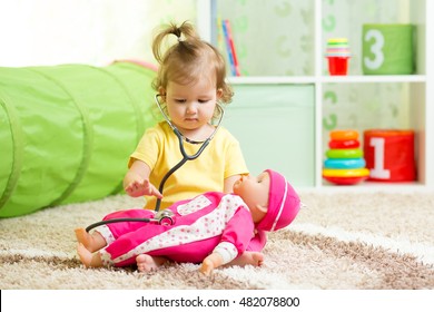 Kid Girl Playing With A Doll In Playroom