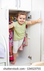 kid girl playing and hiding inside wardrobe