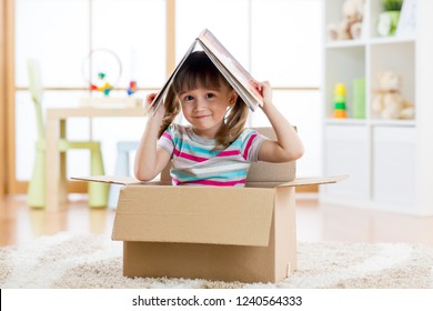 Kid Girl Playing In A Toy House In Nursery Room