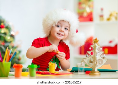 Kid Girl In Santa Hat Making Christmas Tree Of Plasticine