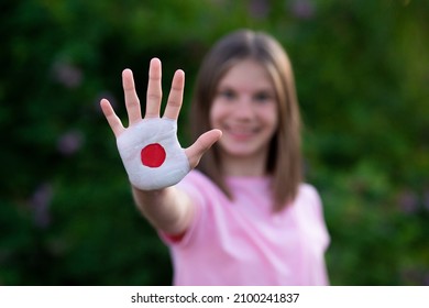 Kid Girl Show Stop Gesture With Hands Painted In Japan Flag Colors. Reopen School, Healthcare. Education Abroad. Learn Japanese. Selective Focus