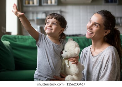 Kid Girl And Single Mother Looking Forward To Good Future Concept, Cute Child Daughter Reaching Out Hand Showing Young Smiling Mom New Goals Dreaming Of Family Happiness Feeling Free And Hopeful